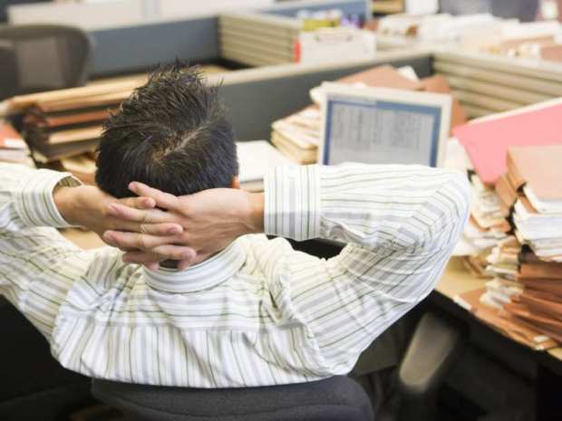 businessman-in-cubicle-with-laptop-and-stacks-of-files-cre